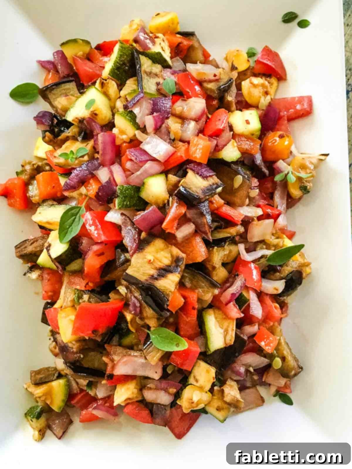 Smoky Grilled Ratatouille Salad 2 Grilled summer vegetables diced into a vibrant ratatouille salad, artfully arranged in a bowl.
