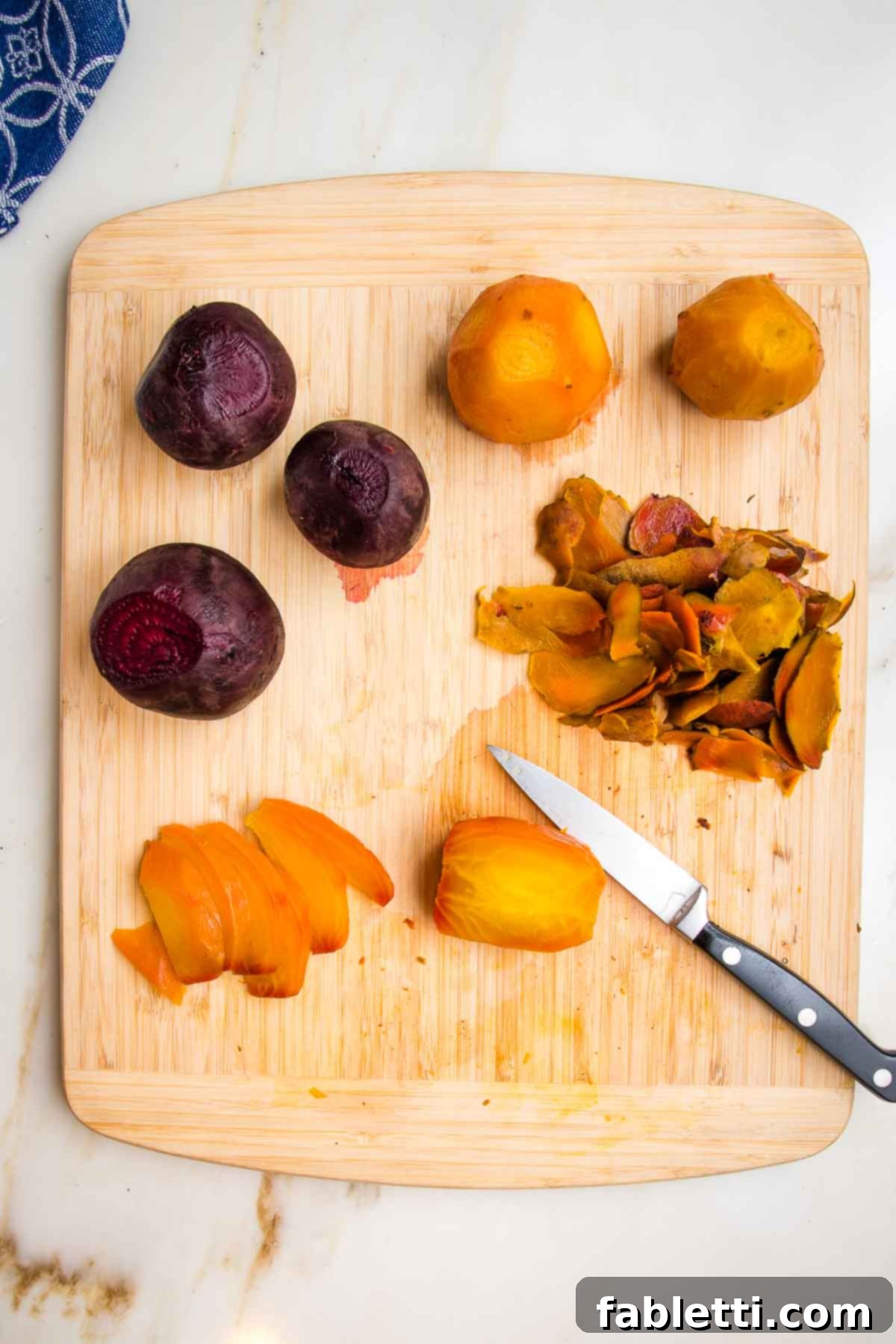 Balsamic Roasted Beet Salad 12 Roasted whole golden beets and red beets, peeled and now being cut into wedges with a paring knife, on a wooden cutting board to make into beet salad.