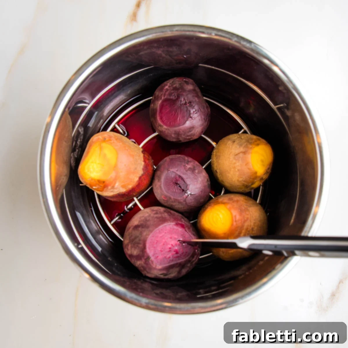 Balsamic Roasted Beet Salad 7 Cooked beets, 3 red, 3 golden, in an instant pot on a rack. Colored water below. Paring knife in one of the beets.