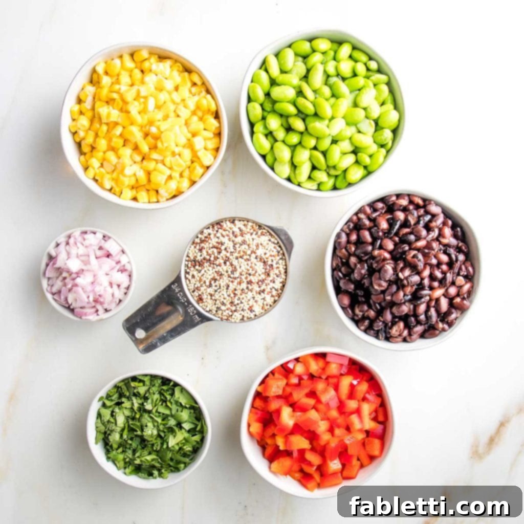 Zesty Southwest Quinoa Salad 4 small bowls with ingredients for quinoa salad: yellow corn, green edamame, black beans, minced shallot, chopped fresh cilantro, raw uncooked quinoa, black beans, diced red peppers