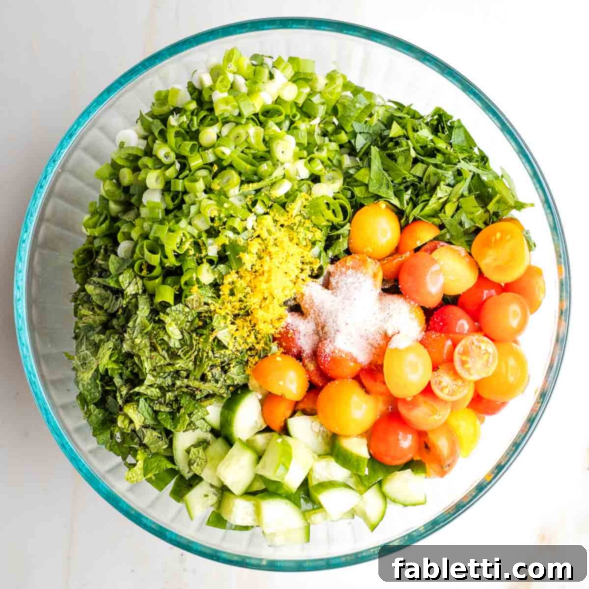 Sweet Parsnip Gluten-Free Tabbouleh 13 Large bowl with sections of tomatoes, cucumbers, fresh herbs, scallions, lemon zest, salt and pepper.