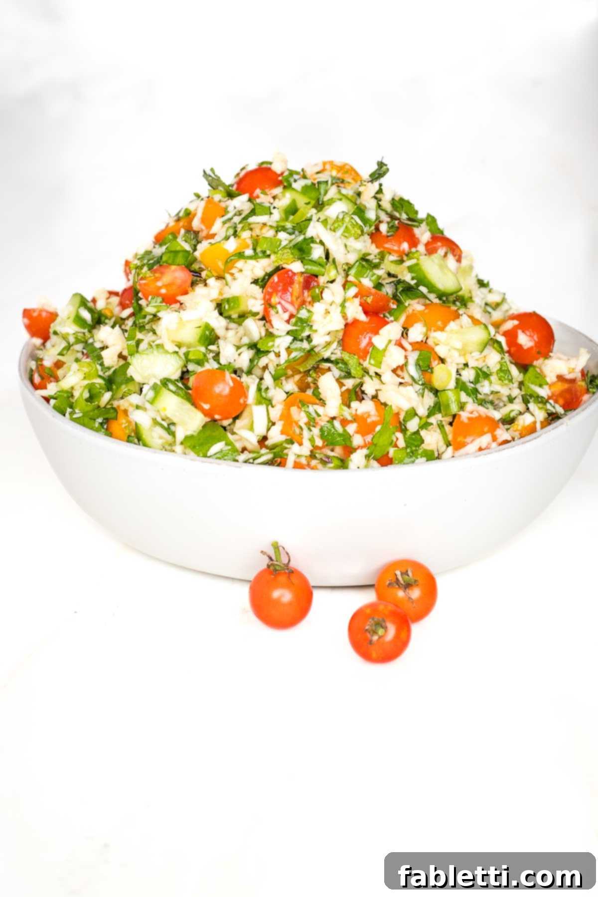 Sweet Parsnip Gluten-Free Tabbouleh 16 White bowl piled high with tabbouleh that's loaded with fresh tomatoes and cucumbers, lots of fresh herbs, scallions and riced parsnips.