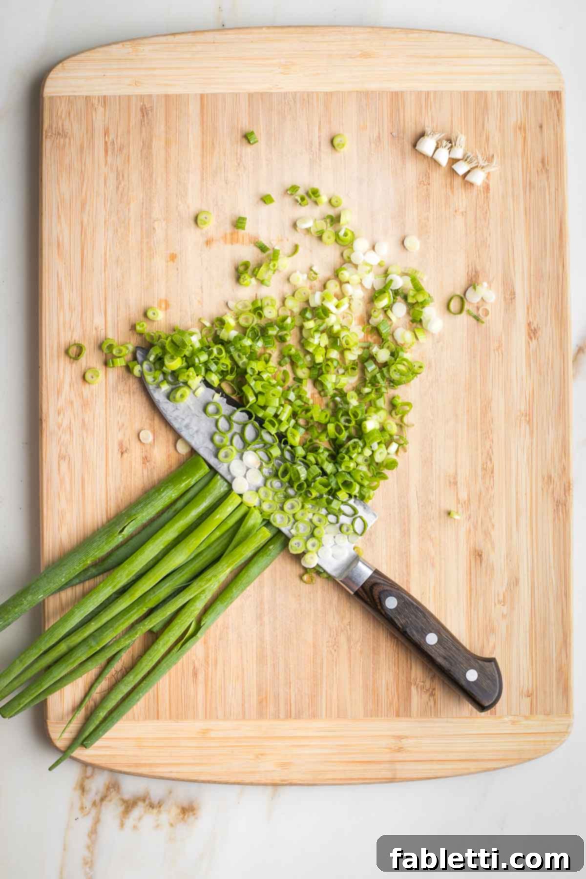 Sweet Parsnip Gluten-Free Tabbouleh 4 Slicing green onions on a wooden cutting board.