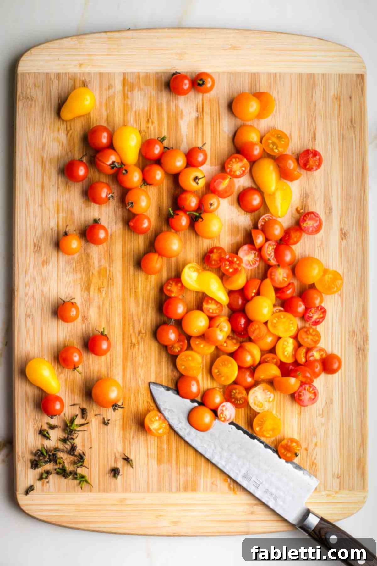 Sweet Parsnip Gluten-Free Tabbouleh 6 Removing stems from cherry and grape tomatoes and then cutting them in half.