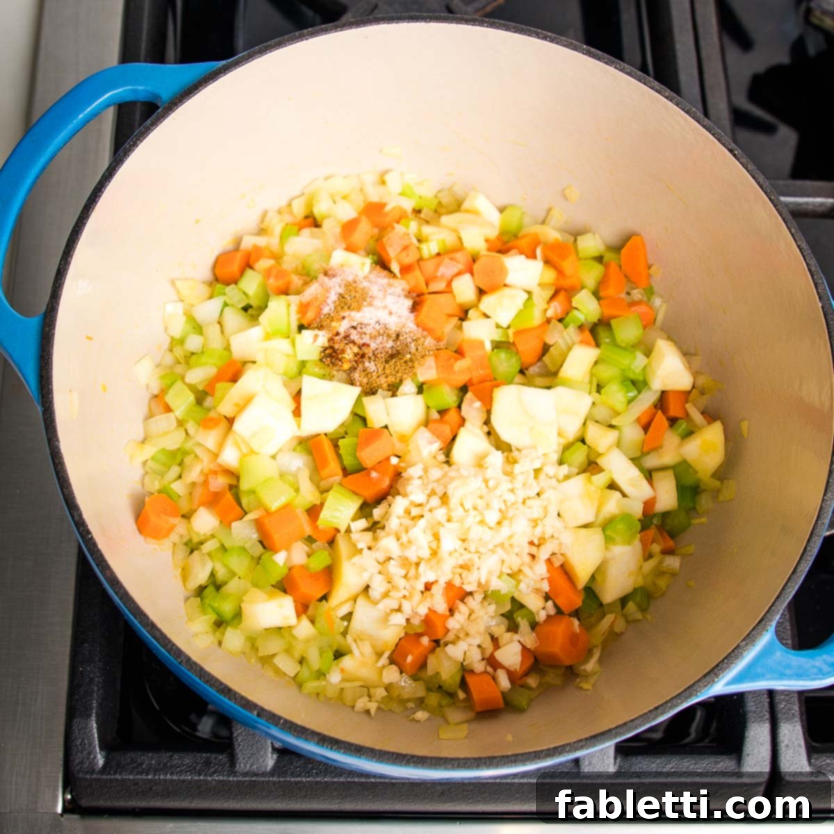 Wholesome Plant-Based Lentil Soup 8 Adding spices to sautéed vegetables in a Dutch oven.