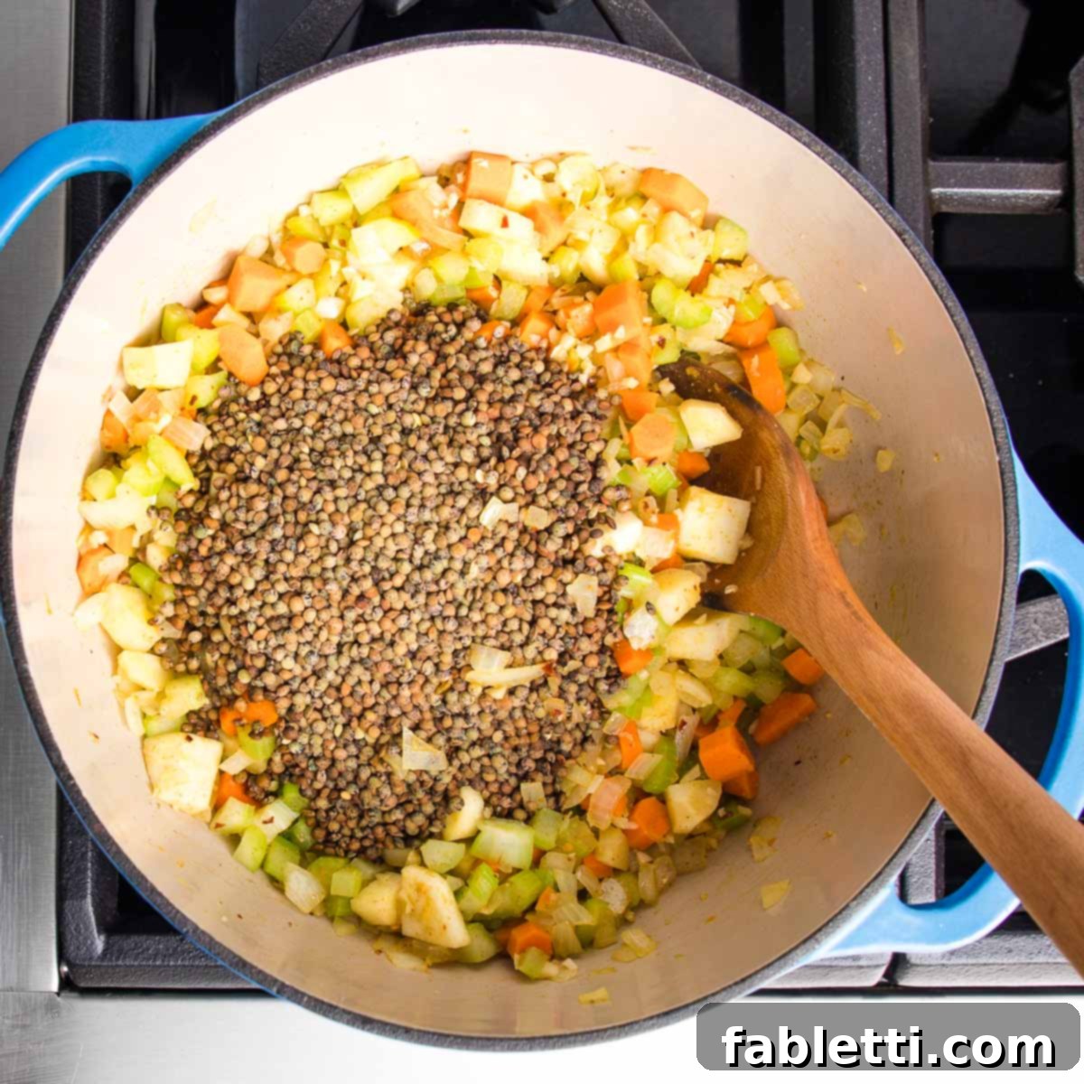 Wholesome Plant-Based Lentil Soup 10 Dutch oven with chopped veggies and small lentils.