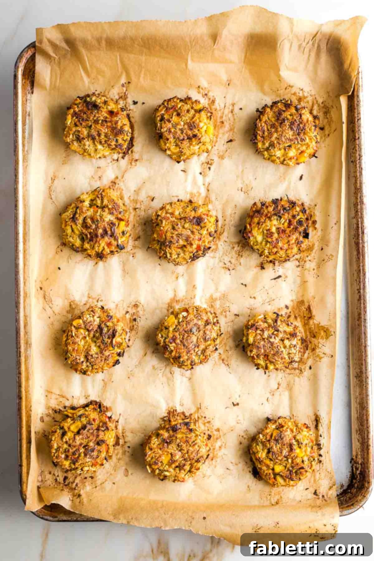 Crisp artichoke cakes on a baking tray.