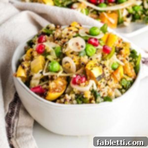 Brightly colored salad with quinoa, pomegranate, roasted squash, peas, shallots.