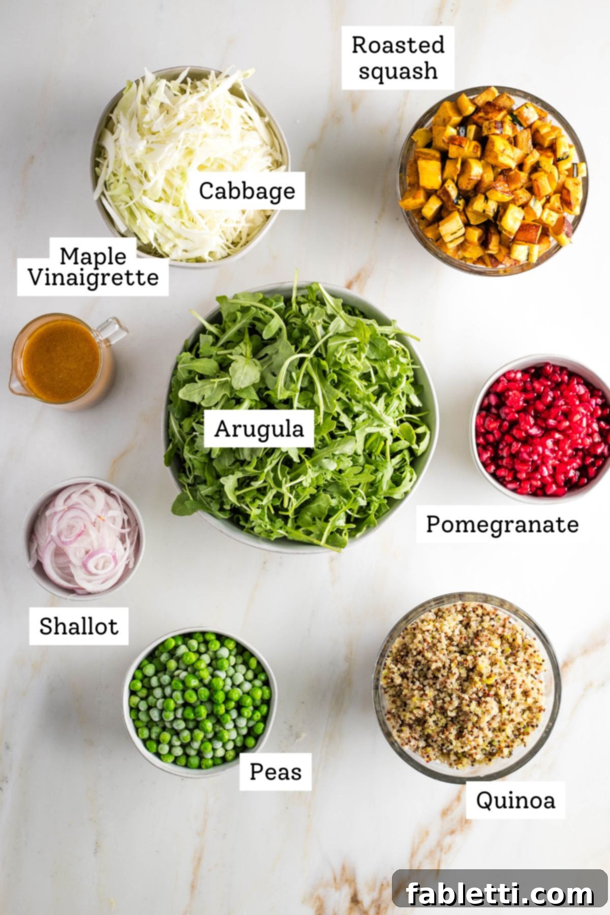 Labeled ingredients: roasted squash cabbage, arugula, pomegranate seeds, cooked quinoa, peas, shallots and maple vinaigrette.