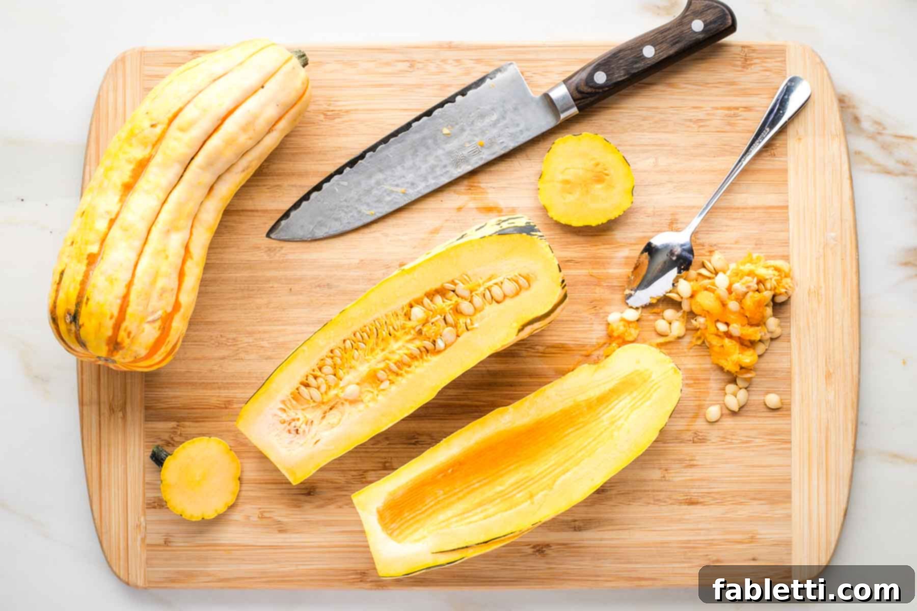 Delicata squash cut in half lengthwise with the seeds scooped out.