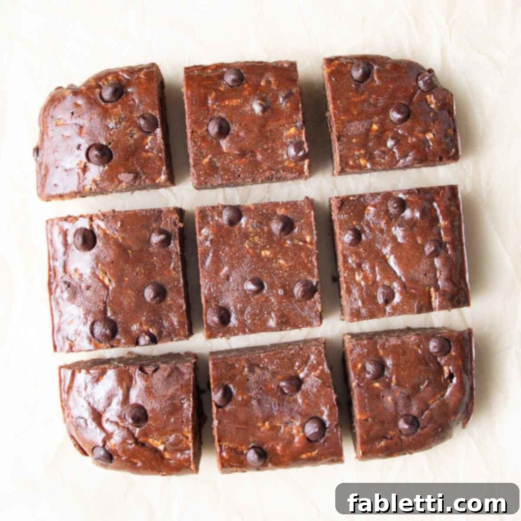 Secret Garden Chocolate Brownies 4 A close-up view of freshly baked chocolate zucchini brownies, cut into neat squares, revealing their moist, rich texture.