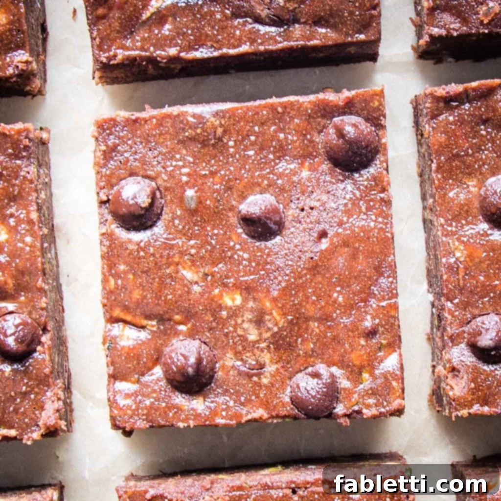 Secret Garden Chocolate Brownies 7 A close-up of a single chocolate brownie square, adorned with visible chocolate chips, promising a rich and satisfying bite.