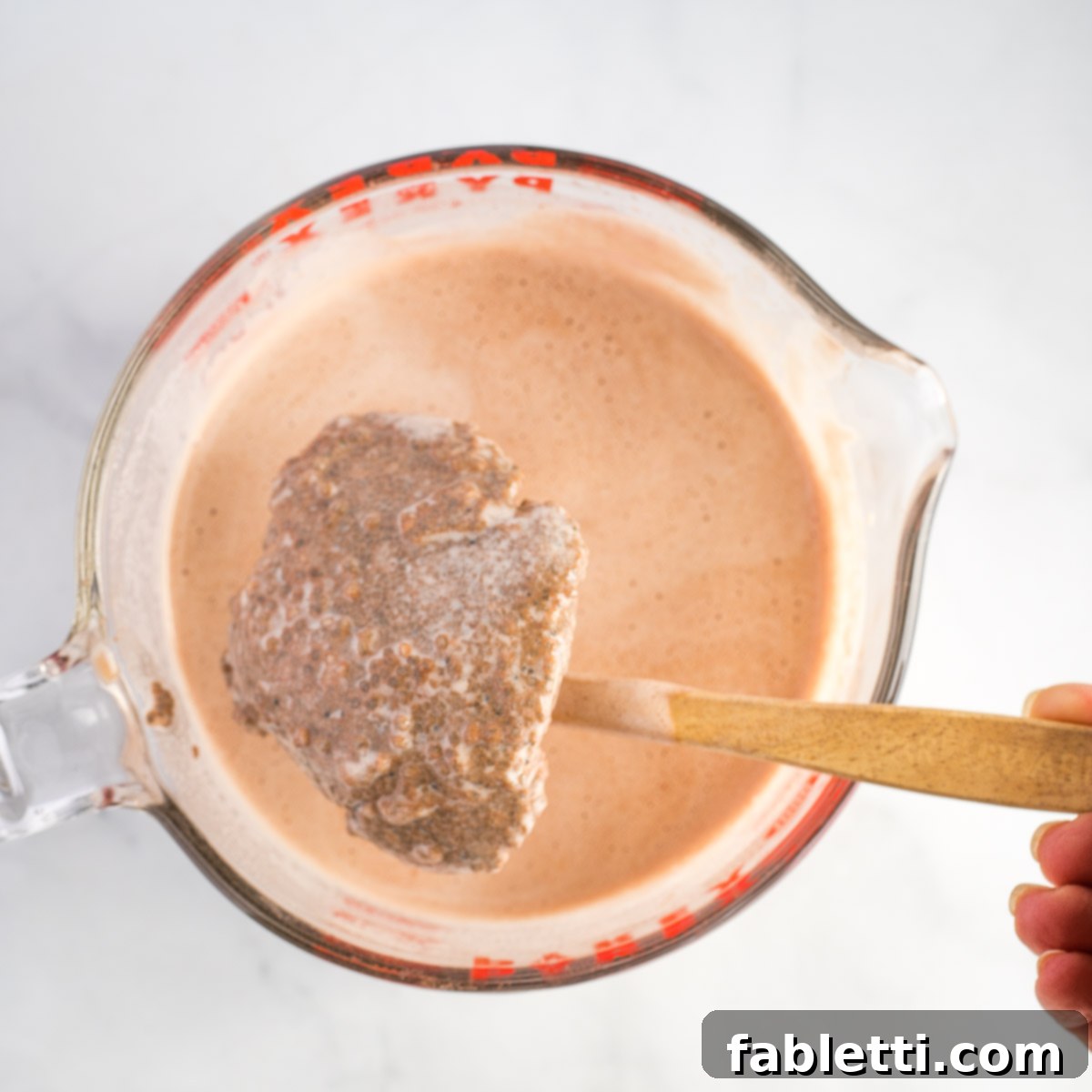 Effortless Chocolate Chia Pudding Bliss 11 Large pyrex mixing cup with chocolate milk and a huge dry clump of chia seeds.