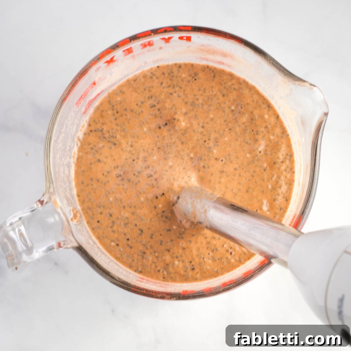 Effortless Chocolate Chia Pudding Bliss 12 Mixing chia seeds into chocolate milk with an immersion blender.