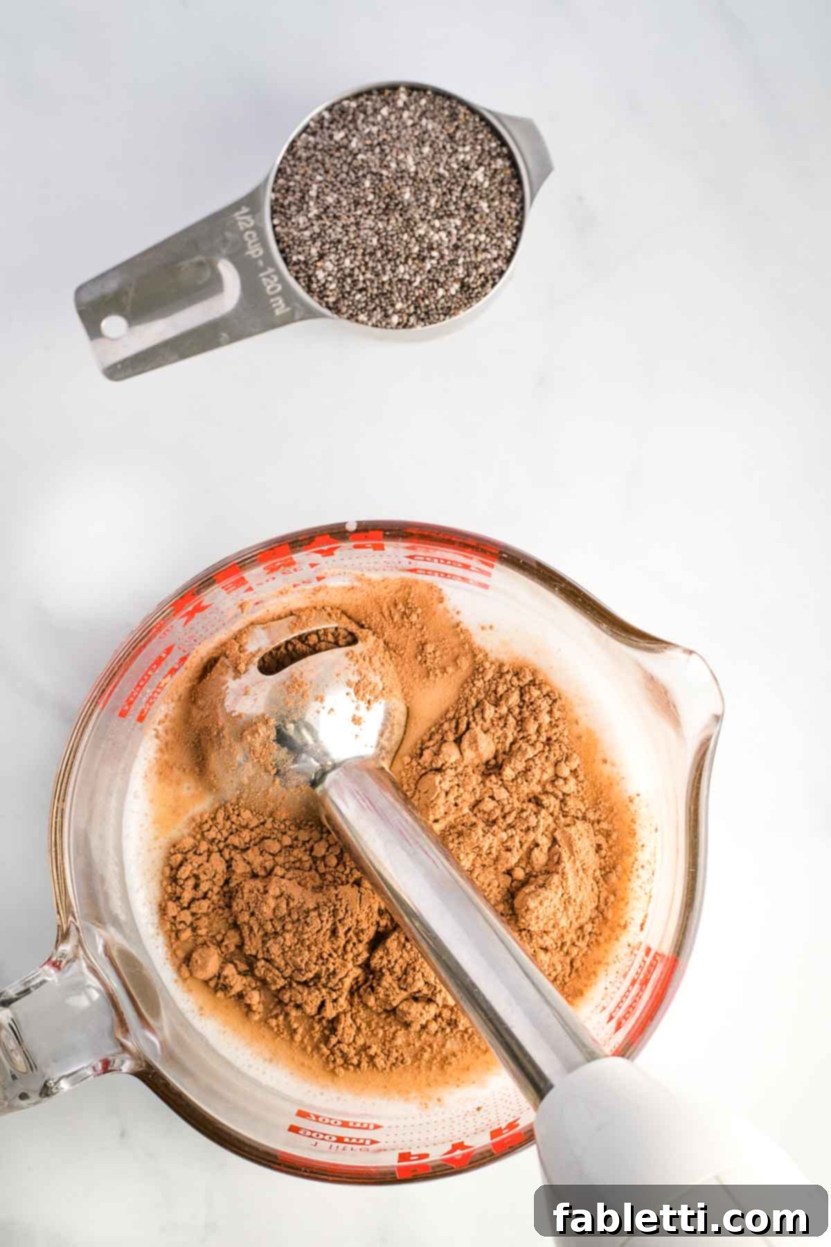 Effortless Chocolate Chia Pudding Bliss 6 Immersion blender combining almond milk with cocoa powder.