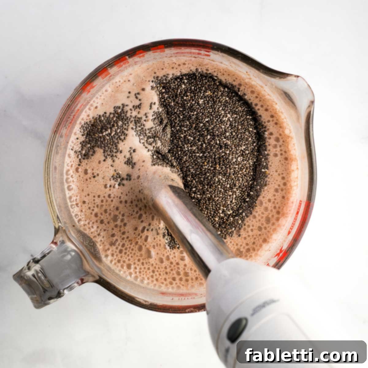 Effortless Chocolate Chia Pudding Bliss 8 Mixing chia seeds into chocolate pudding with an immersion blender.