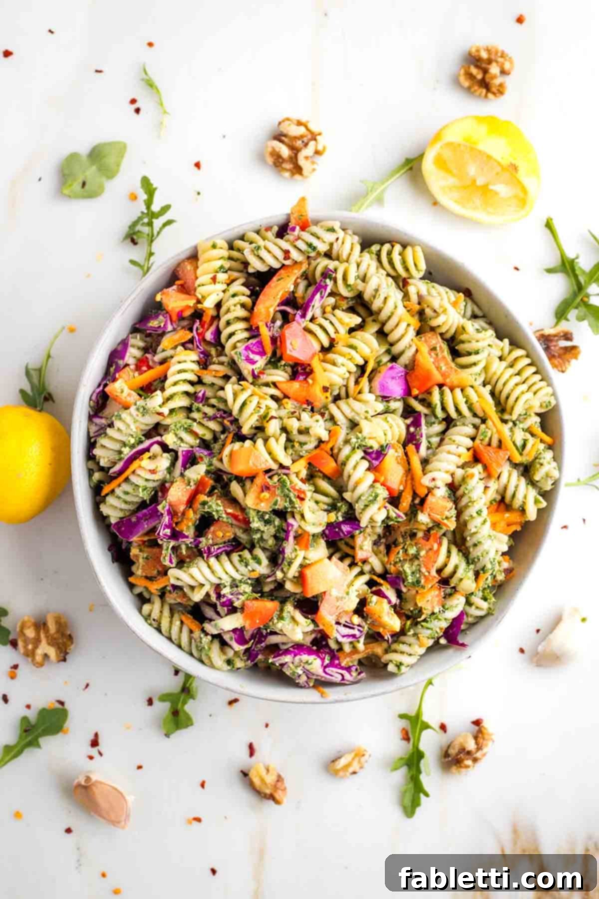 Pesto Pasta Salad Idea A beautifully presented, vibrant, and fresh pasta salad, generously tossed with homemade walnut pesto. The dish is rich with colorful assorted vegetables, making it look incredibly appetizing and healthy for any meal.