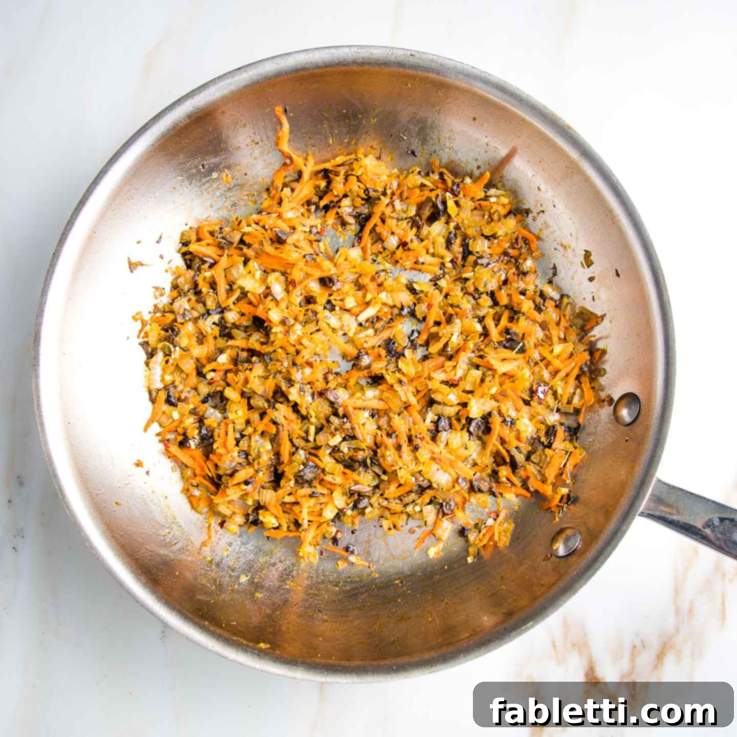 Hearty Homemade White Bean Veggie Burgers 4 A large frying pan filled with beautifully sautéed mushrooms, onions, and shredded carrots, aromatic and tender.