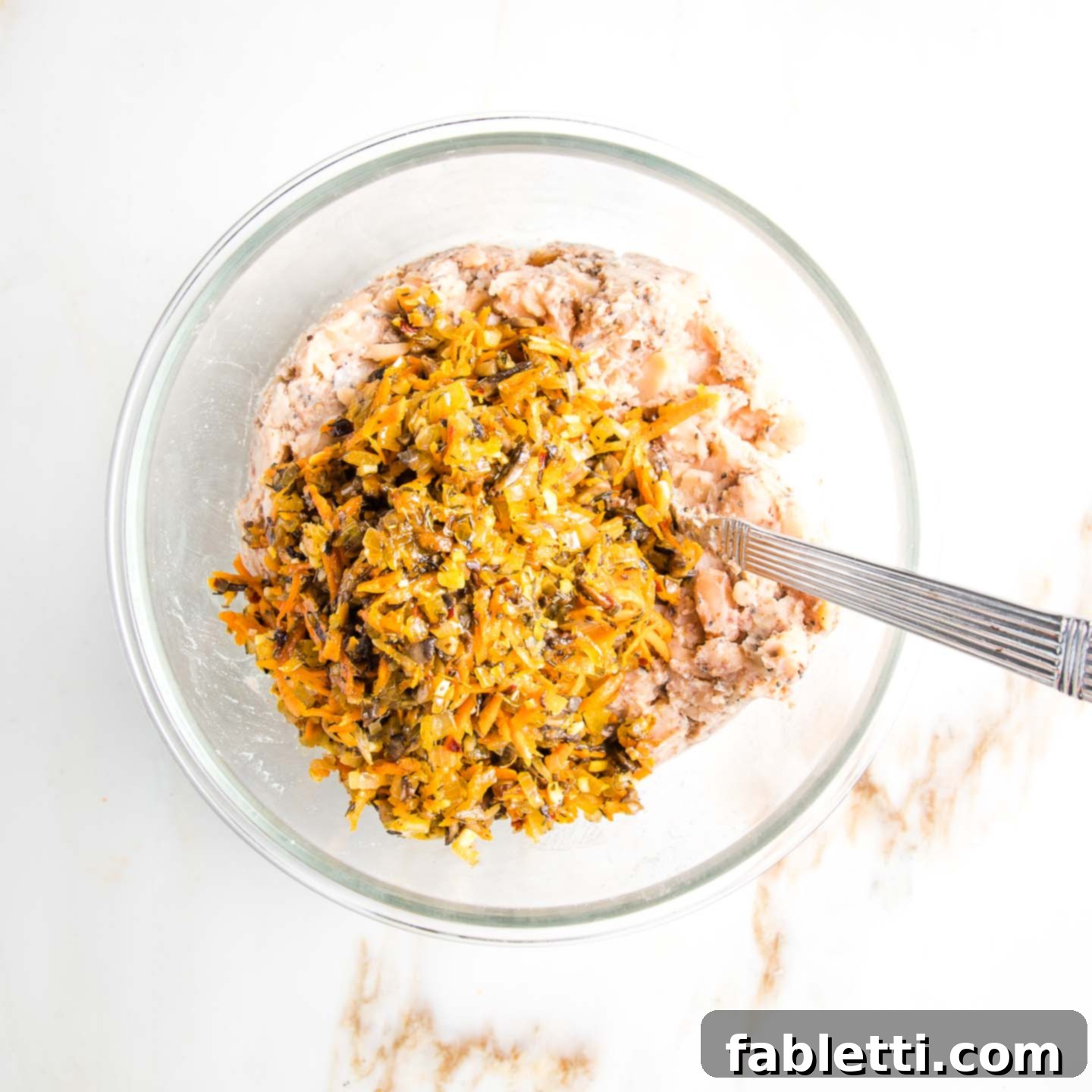 Hearty Homemade White Bean Veggie Burgers 7 The mashed bean mixture in a bowl, with the freshly sautéed vegetables piled on top, awaiting integration.