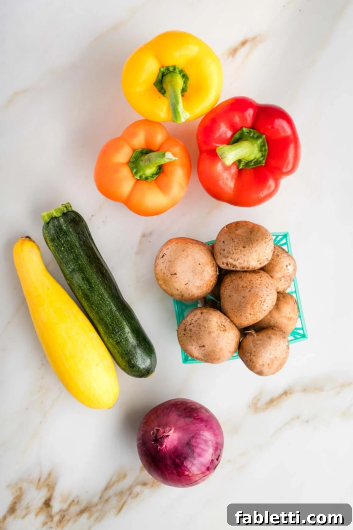 Vibrant Mediterranean Veggie Skewers 3 Assortment of fresh, colorful vegetables ideal for grilling, including whole bell peppers, zucchini, yellow squash, mushrooms, and red onion.