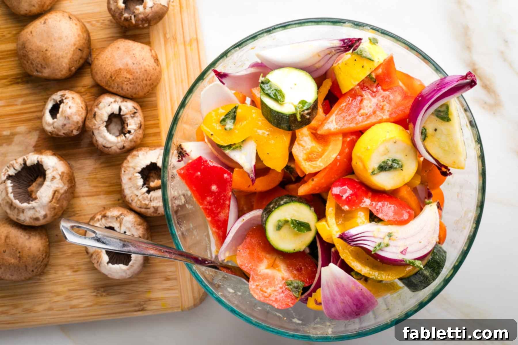 Vibrant Mediterranean Veggie Skewers 6 Bowl of mixed, cut vegetables marinating in a flavorful sauce, with additional mushrooms waiting on a cutting board nearby.