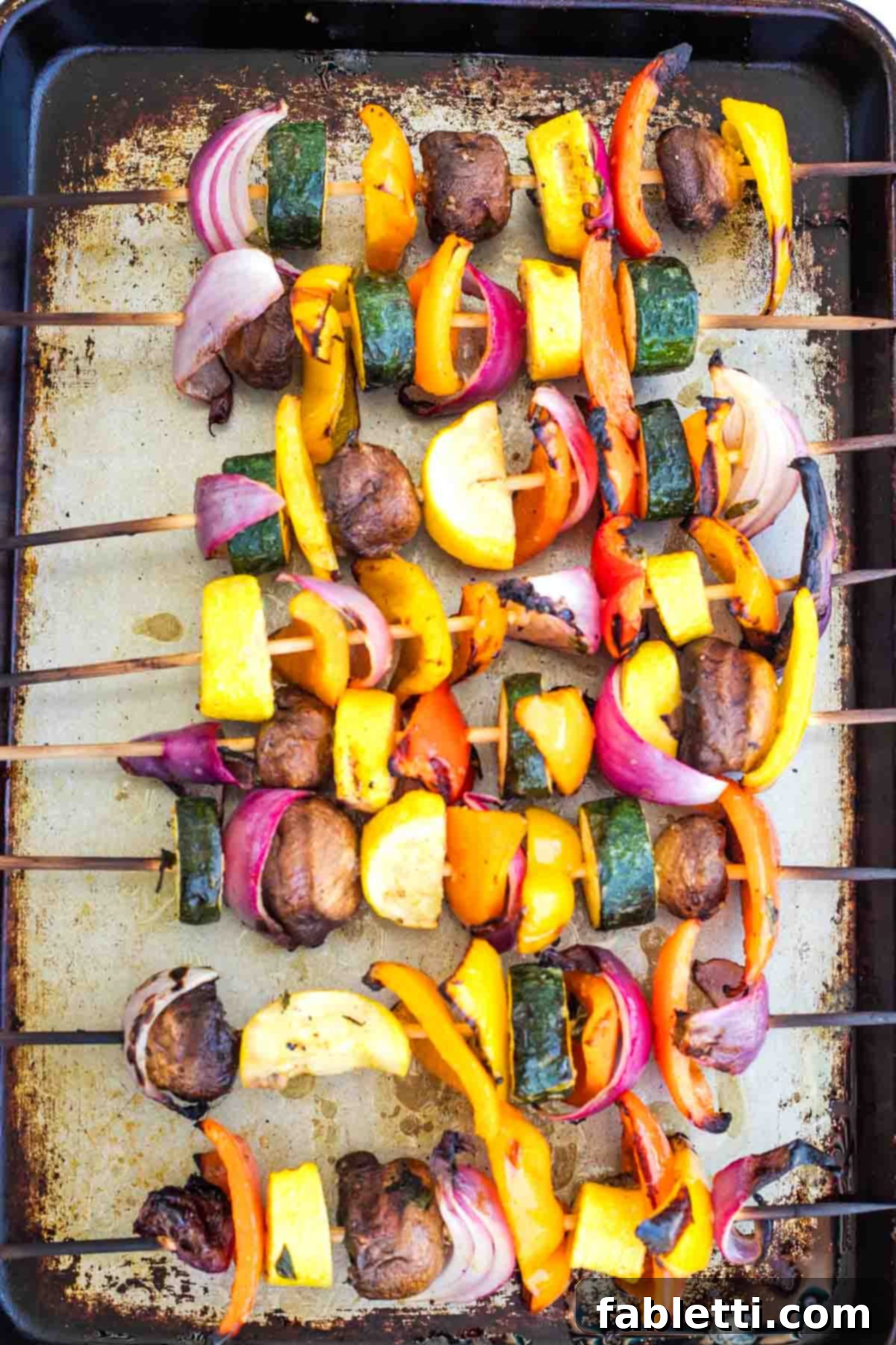 Vibrant Mediterranean Veggie Skewers 10 Finished grilled vegetable skewers arranged neatly on a sheet pan, showing ideal charring and tenderness.