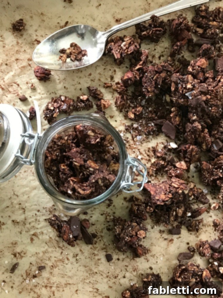 Nourishing Chocolate Oat Granola 8 Jar filled with chocolate granola straight from a baking pan.