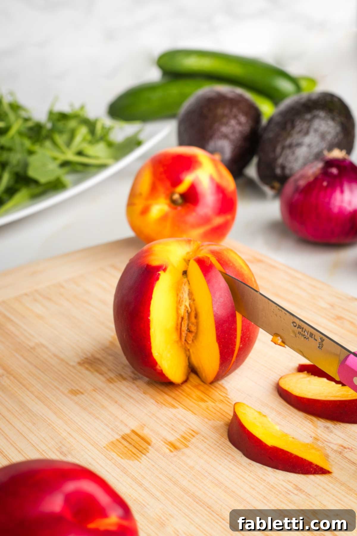 Vibrant Nectarine Arugula Salad 5 Nectarine on a cutting board, a paring knife making a vertical slice along the pit.
