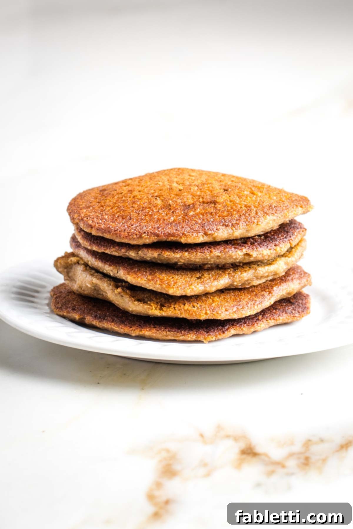 Effortless Vegan Banana Oat Blender Pancakes 7 Stack of vegan oat and banana pancakes on a plate.