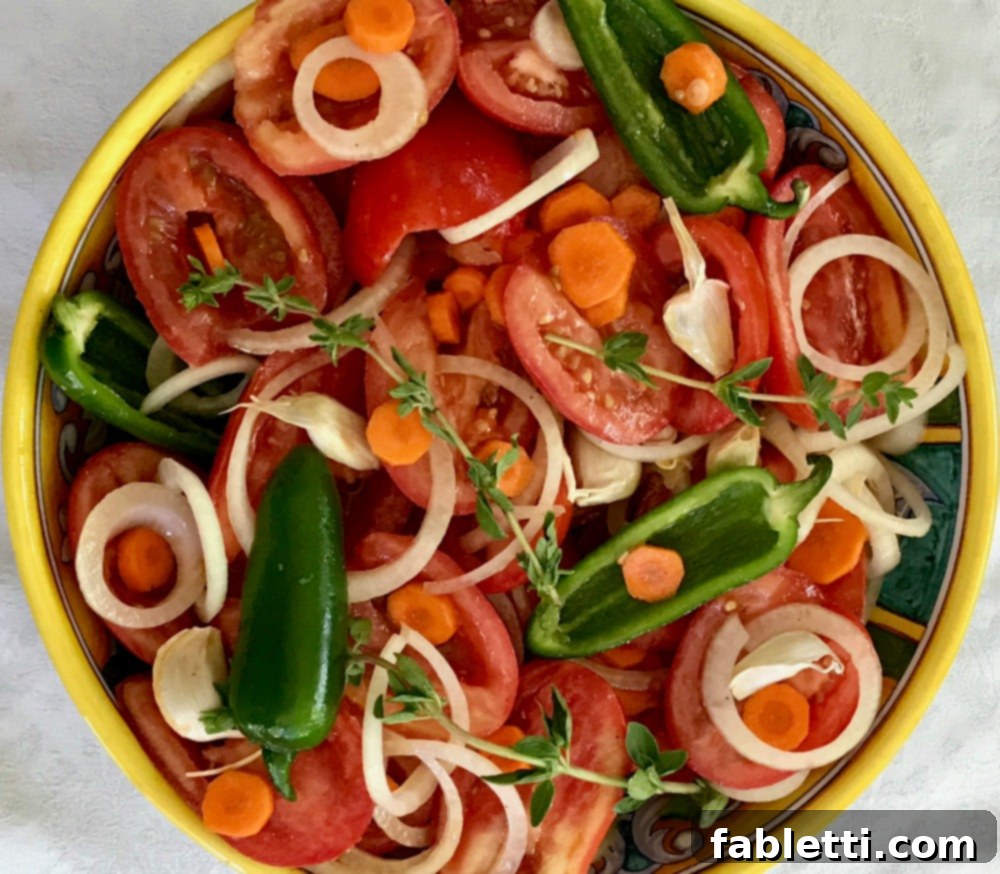 Rustic Roasted Tomato Sauce 4 A colorful array of delicious summer produce, including tomatoes, onions, and carrots.