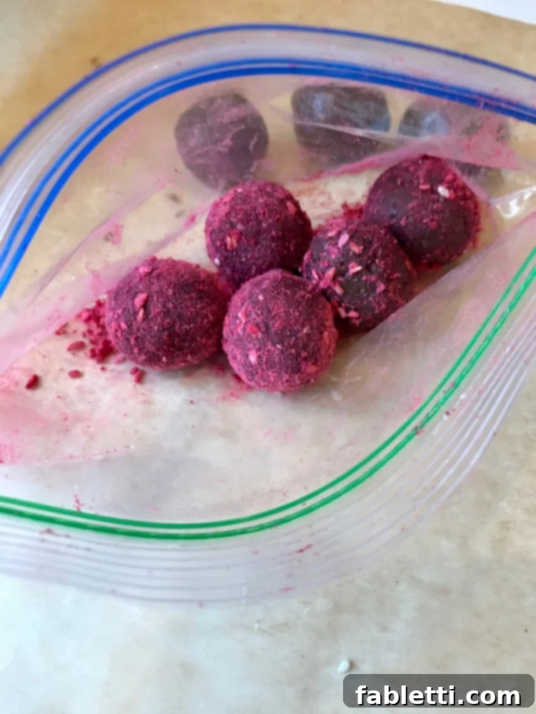 Sweet Halva Delights 5 Ziploc baggie with a few chocolate bliss balls that are coated in a reddish pink powder.