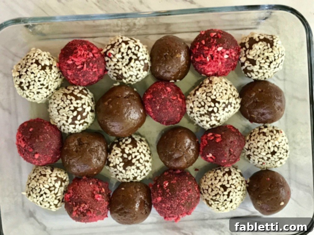 Sweet Halva Delights 7 Six Halva Bliss Balls, some with raspberry coating and some with sesame seeds, stacked in a pyramid shape.