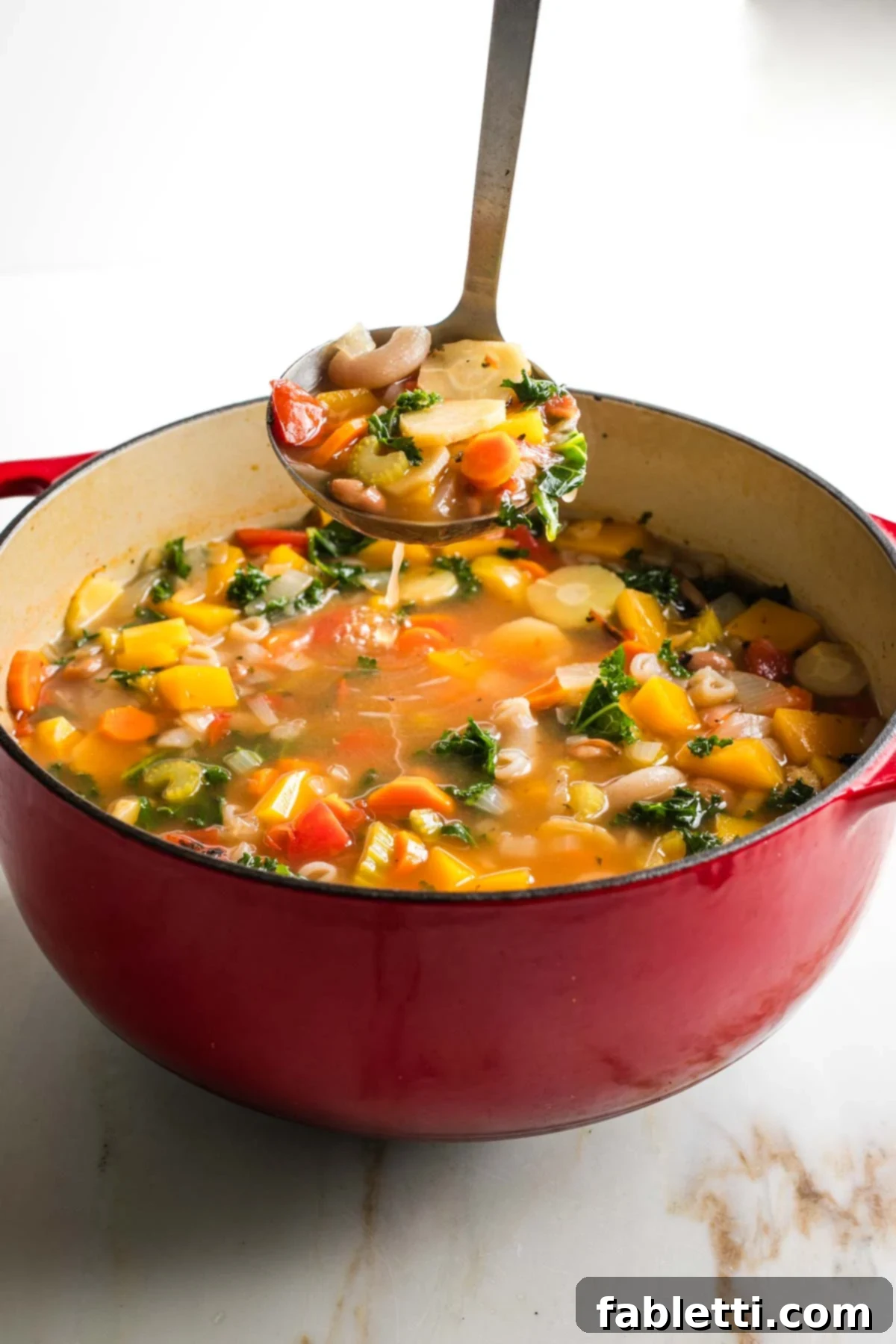 Hearty Fall Vegan Minestrone 12 Ladling chunky minestrone soup from a dutch oven.