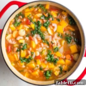 Hearty Fall Vegan Minestrone 14 Chunky minestrone soup with veggies, beans, pasta and wilted kale in a dutch oven.