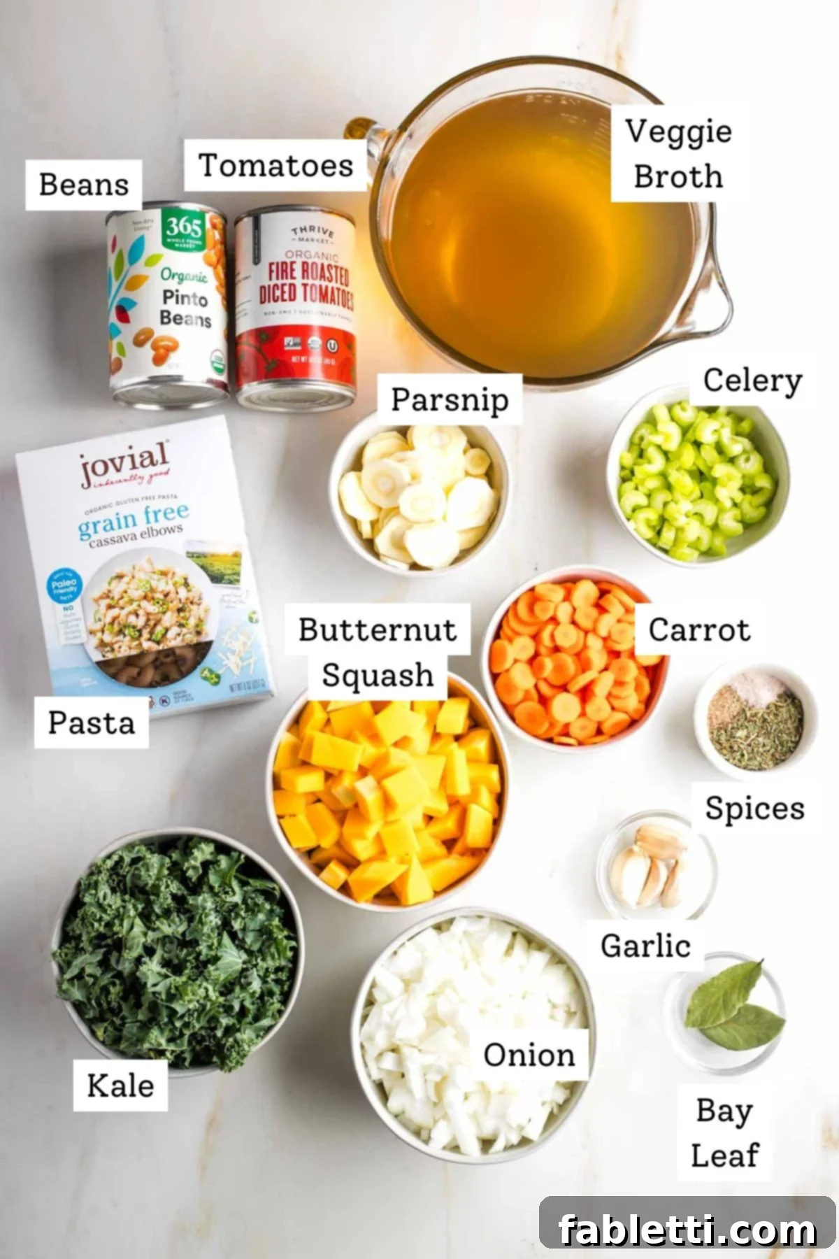 Hearty Fall Vegan Minestrone 3 Labeled ingredients: vegegie broth, canned beans and tomatoes, celery, carrot, parsnip, butternut squash, kale, spices, garlic pasta.