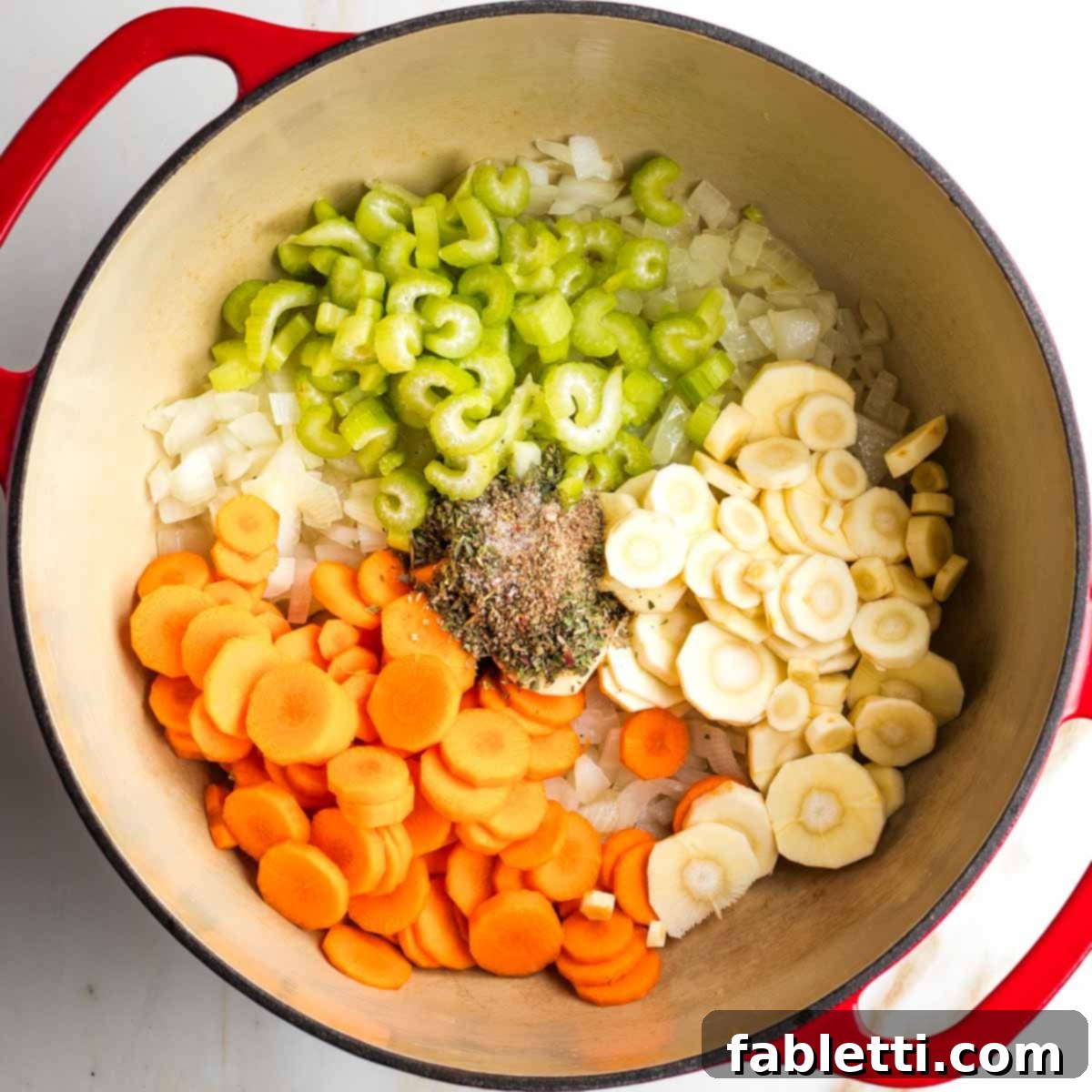 Hearty Fall Vegan Minestrone 6 Dutch oven with carrots, parsnips, spices and celery on top of sauteed onions.