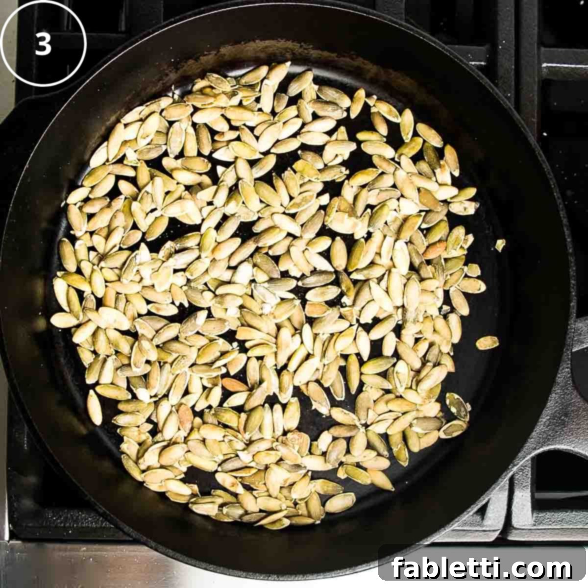 Velvety Vegan Butternut Bliss 12 Pumpkin seeds in a single layer in a cast iron skillet.