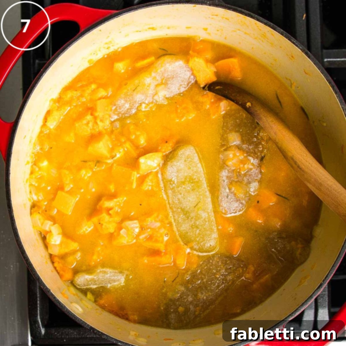 Velvety Vegan Butternut Bliss 16 Butternut squash soup with cubes of stock floating in dutch oven with roasted veggies.