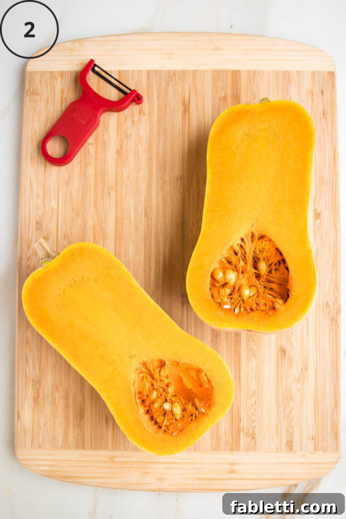 Velvety Vegan Butternut Bliss 7 Butternut squash halved lengthwise, flesh side up on a cutting board.