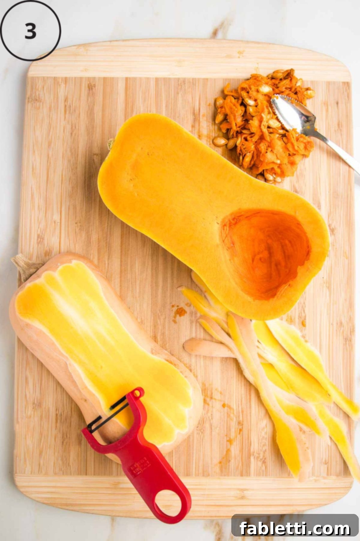 Velvety Vegan Butternut Bliss 8 Butternut squash, halved, seeds scooped out and now being peeled by a "Y" vegetable peeler.