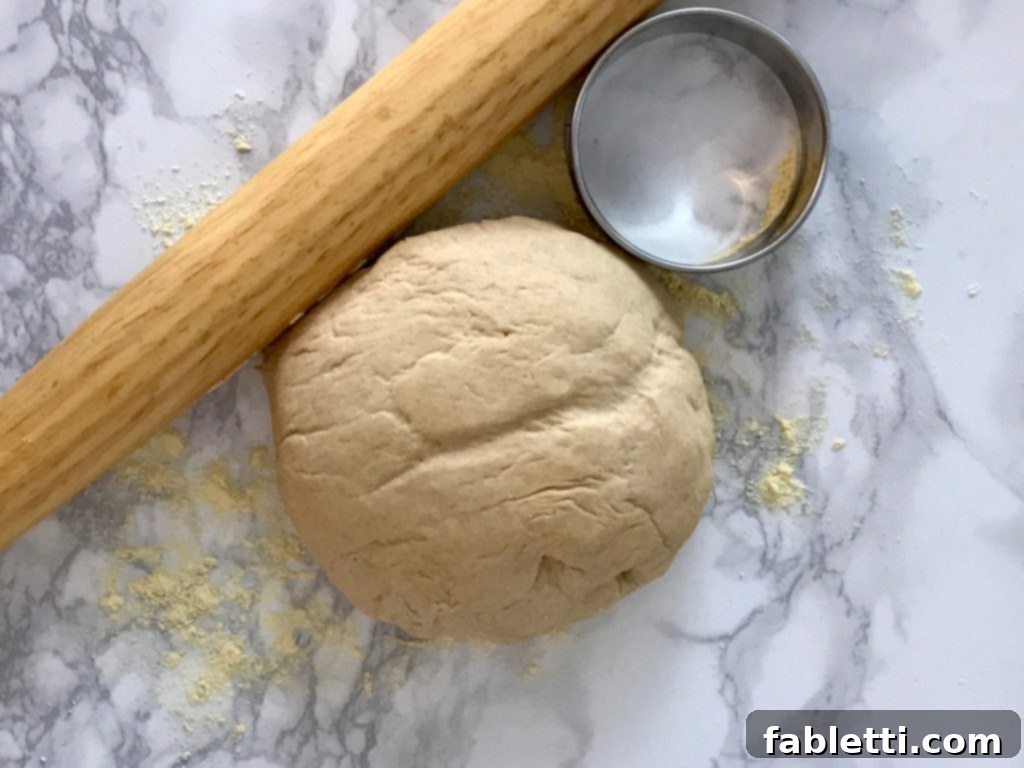 Pillowy Vegan Pizza Muffins with Ricotta Swirl 3 Close-up of pizza dough, a rolling pin, and a circular cookie cutter, ready for making mini pizza muffins.