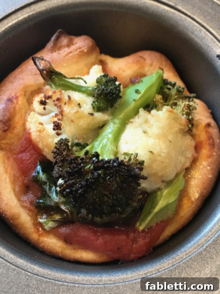 Pillowy Vegan Pizza Muffins with Ricotta Swirl 5 A close-up of a single vegan ricotta pizza muffin, revealing the creamy cauliflower ricotta and vibrant roasted broccoli on top.