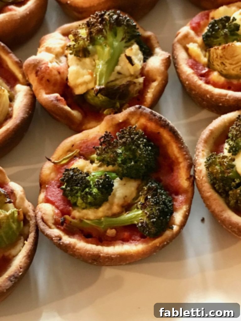 Pillowy Vegan Pizza Muffins with Ricotta Swirl 9 A close-up shot of several vegan ricotta pizza muffins on a cooling rack, showcasing their golden crusts and diverse toppings.