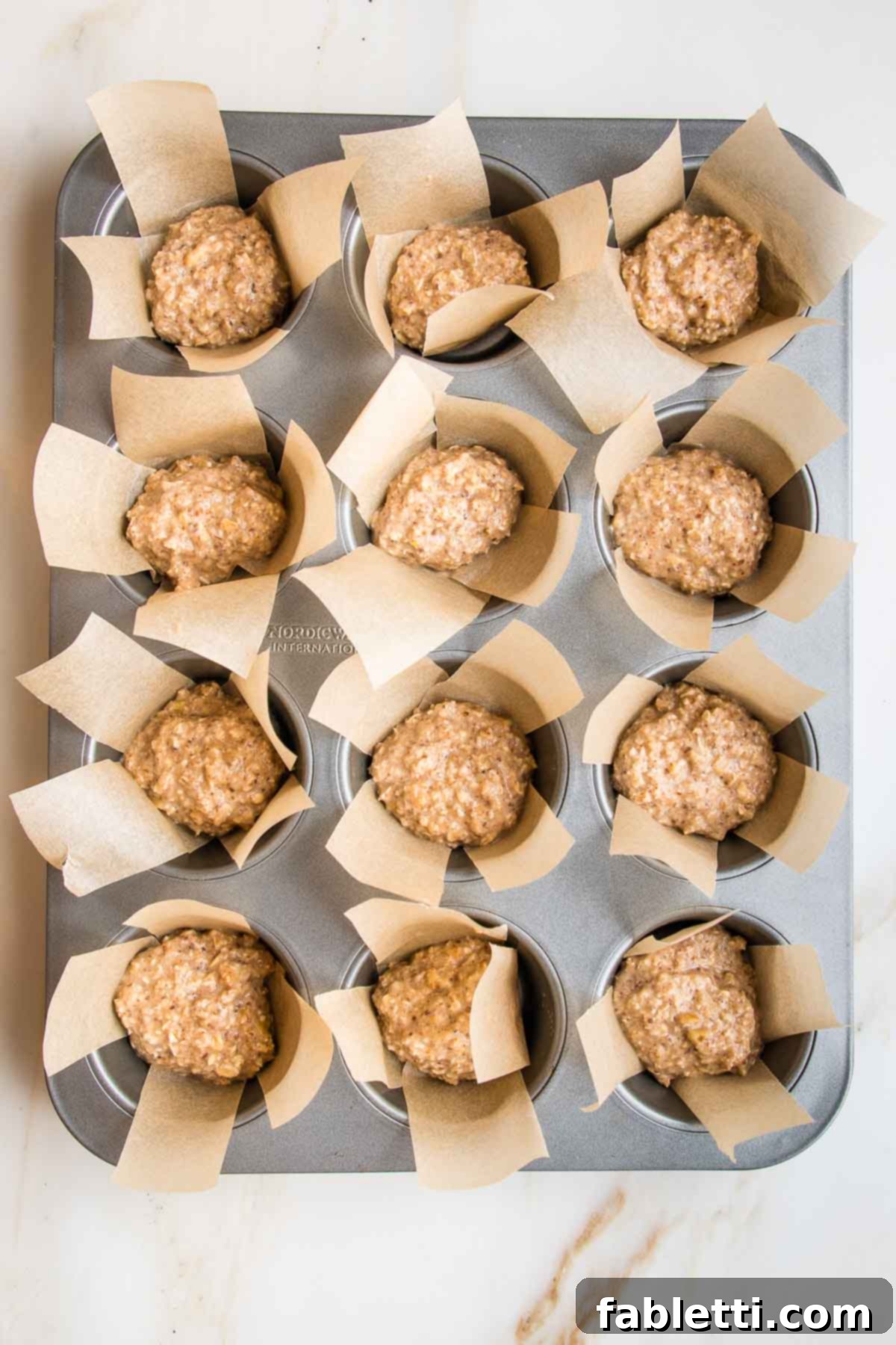 muffin tin, lined with strips of parchment paper and half way filled with oatmeal batter