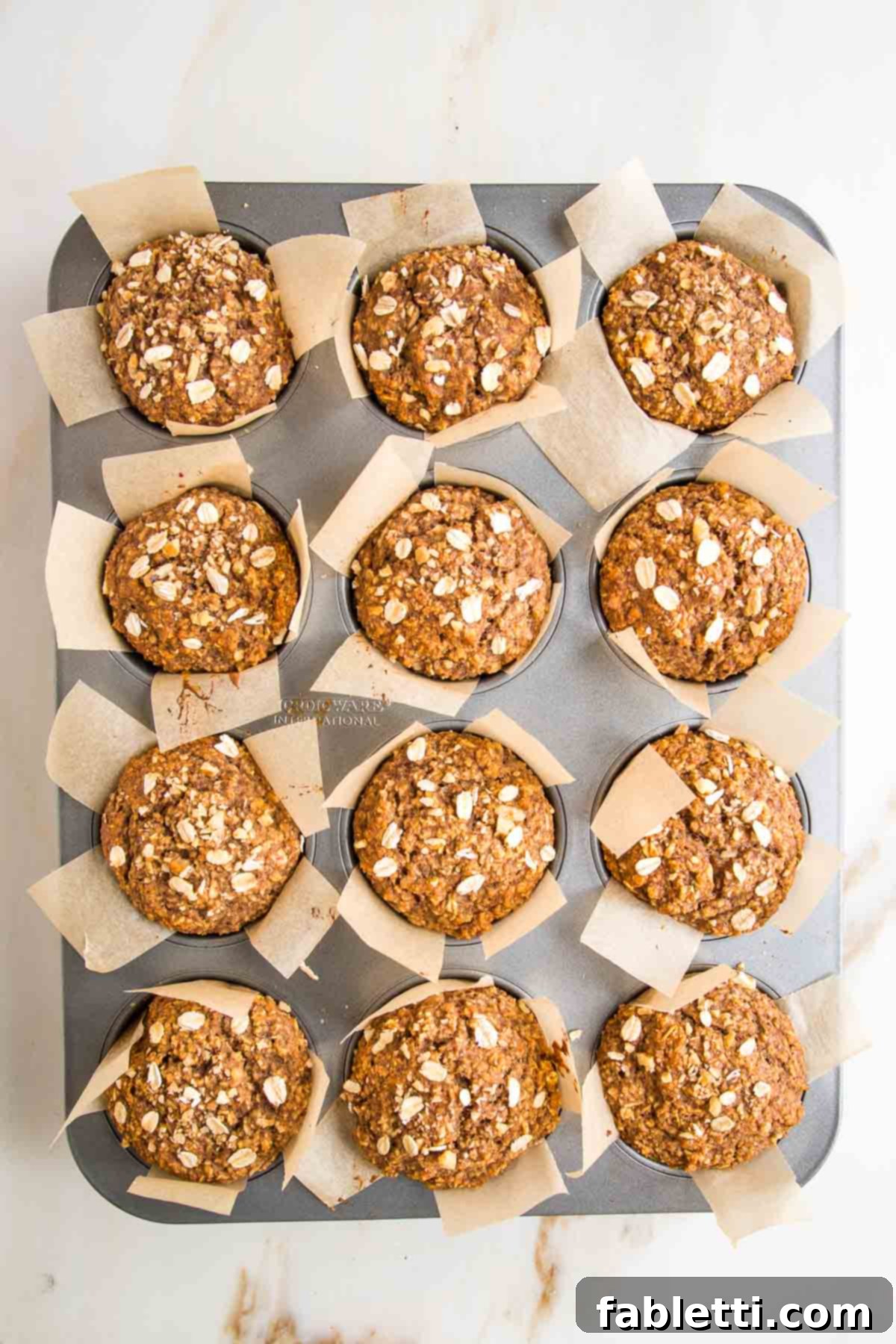 Baked Oatmeal muffins in a tin with parchment strip liners.