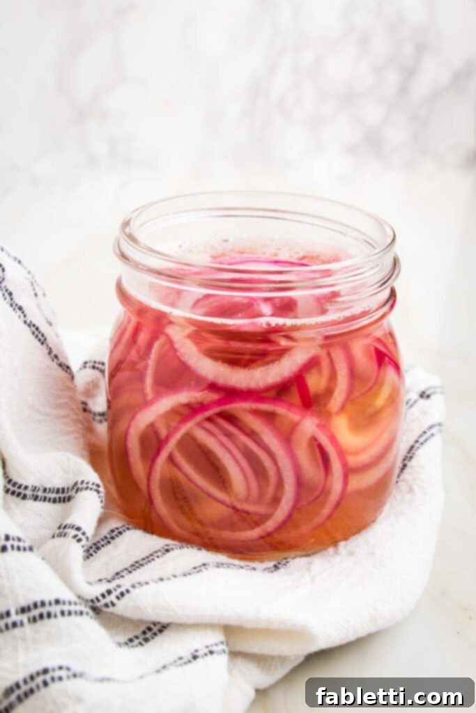 Deliciously Healthy Baked Falafel 16 Pickling liquid being poured over red onions in a jar.