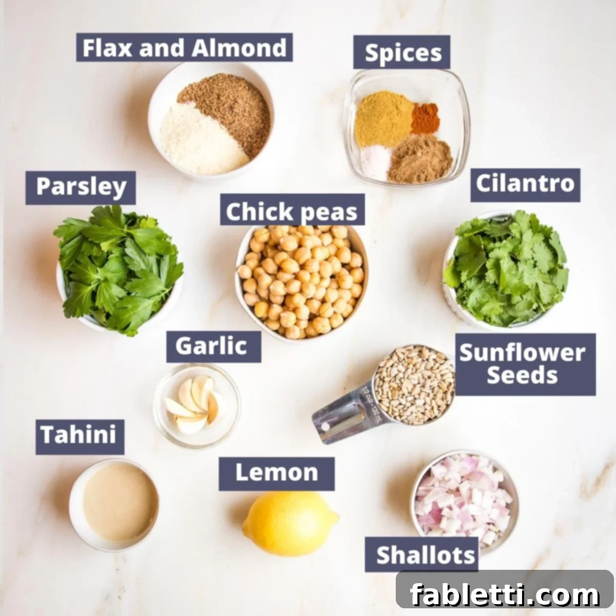 Deliciously Healthy Baked Falafel 3 A vibrant array of fresh and pantry ingredients laid out for making falafel: cooked chickpeas, fresh parsley, fresh cilantro, raw sunflower seeds, garlic cloves, tahini paste, a bright lemon, and a selection of aromatic spices, alongside flax seeds and almond flour for coating.