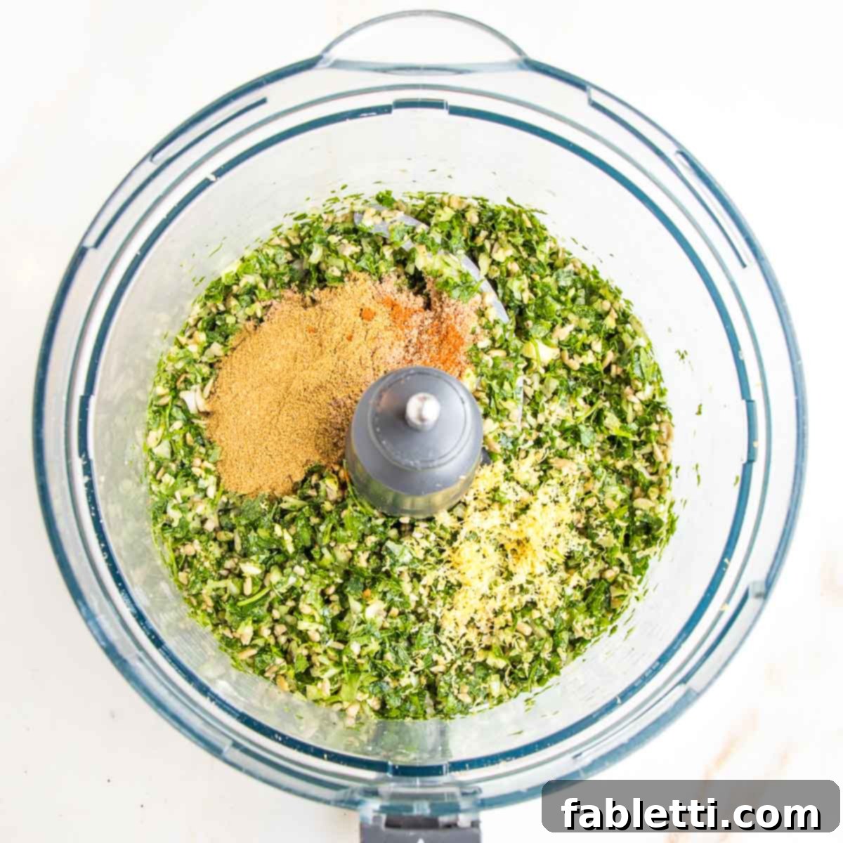Deliciously Healthy Baked Falafel 7 The finely ground mixture of herbs, seeds, and shallots in the food processor, now seasoned with dried herbs and bright yellow lemon zest, ready for the next step.