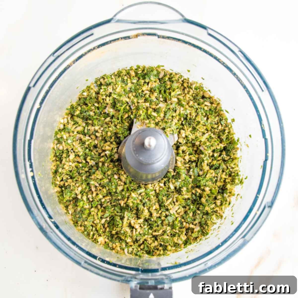 Deliciously Healthy Baked Falafel 8 The food processor bowl now contains a thoroughly mixed blend of ground herbs, spices, and nuts, creating an aromatic and flavorful base for the falafel mixture.