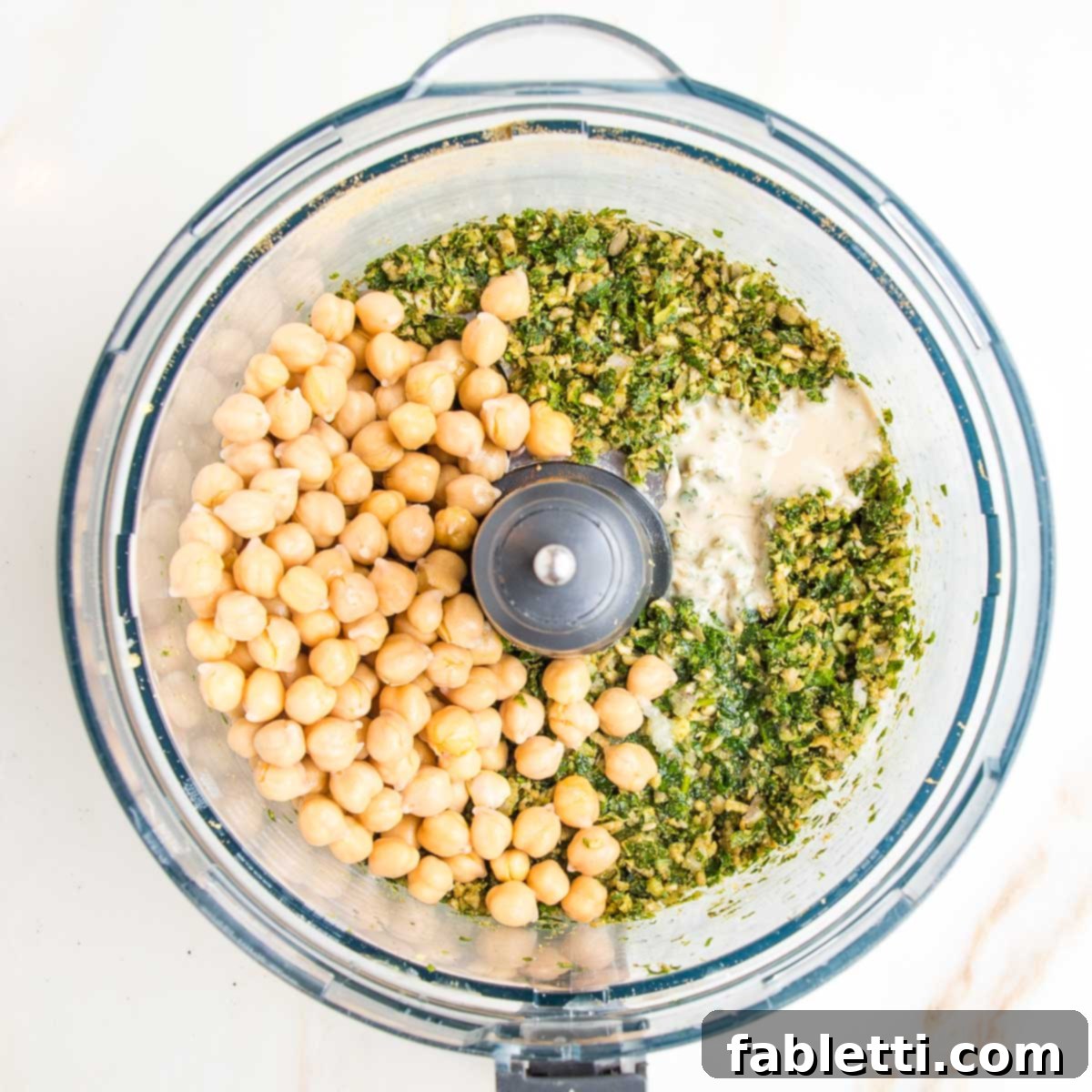 Deliciously Healthy Baked Falafel 9 The food processor bowl now holds the ground fresh herbs, spices, and seeds, enriched with chickpeas and creamy tahini, forming a thick, ready-to-be-pulsed falafel mixture.